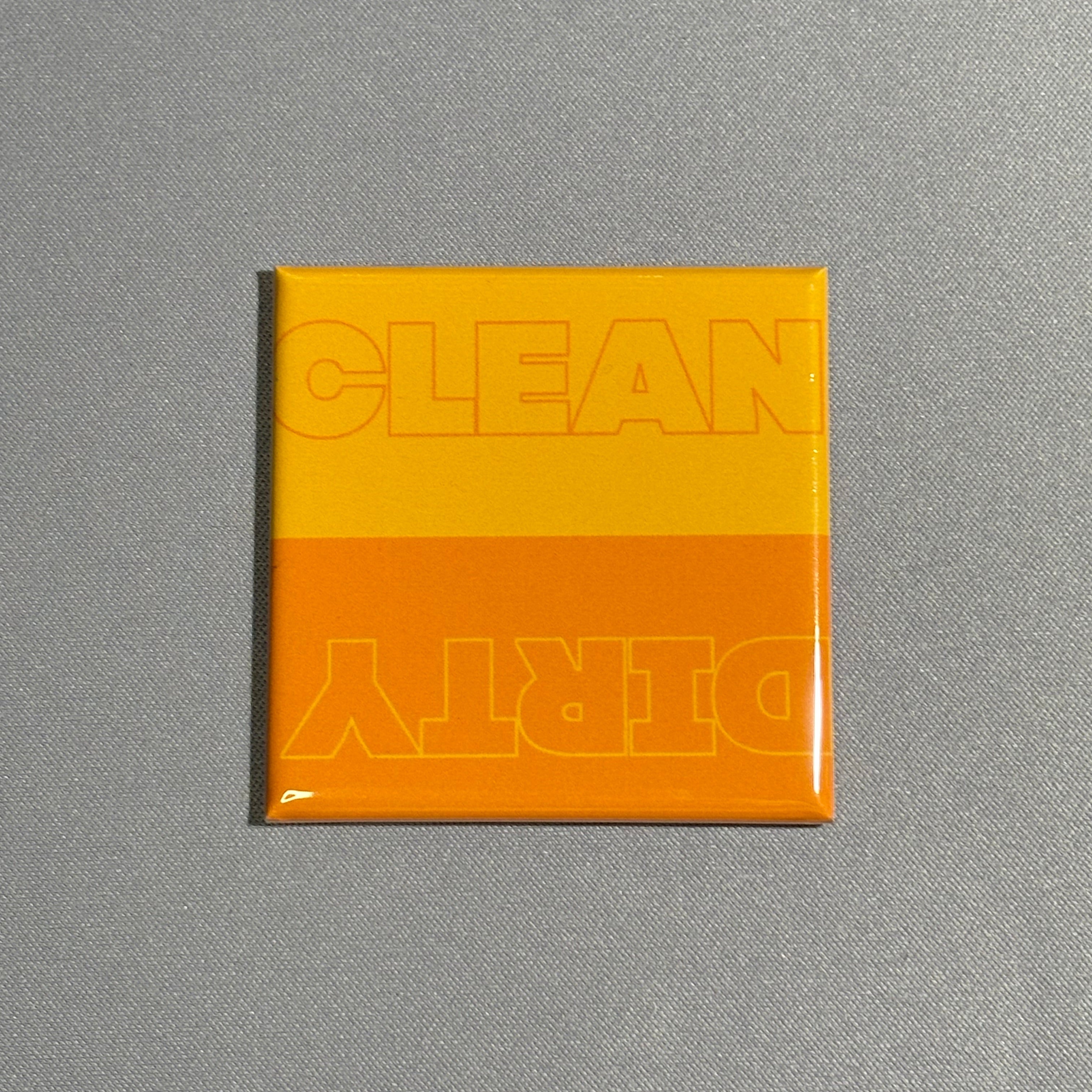 A square magnet with the words clean and dirty on top in an orange color variation. Used for dishwasher.